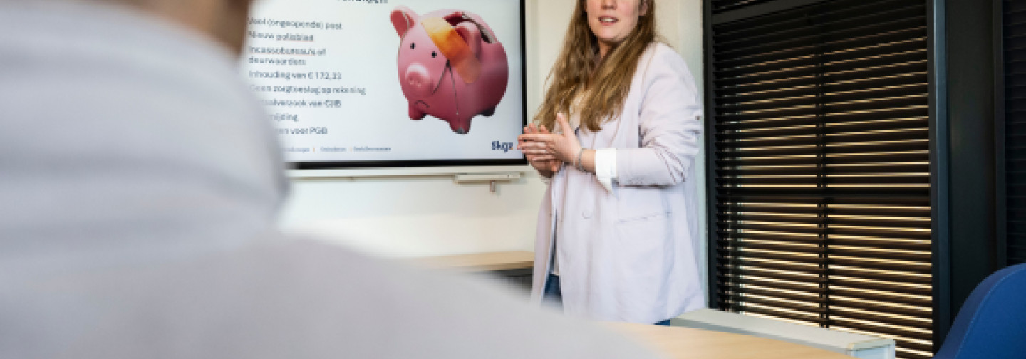 Trainer met deelnemers in gesprek over het aanpakken van beginnende zorgverzekeringsschulden