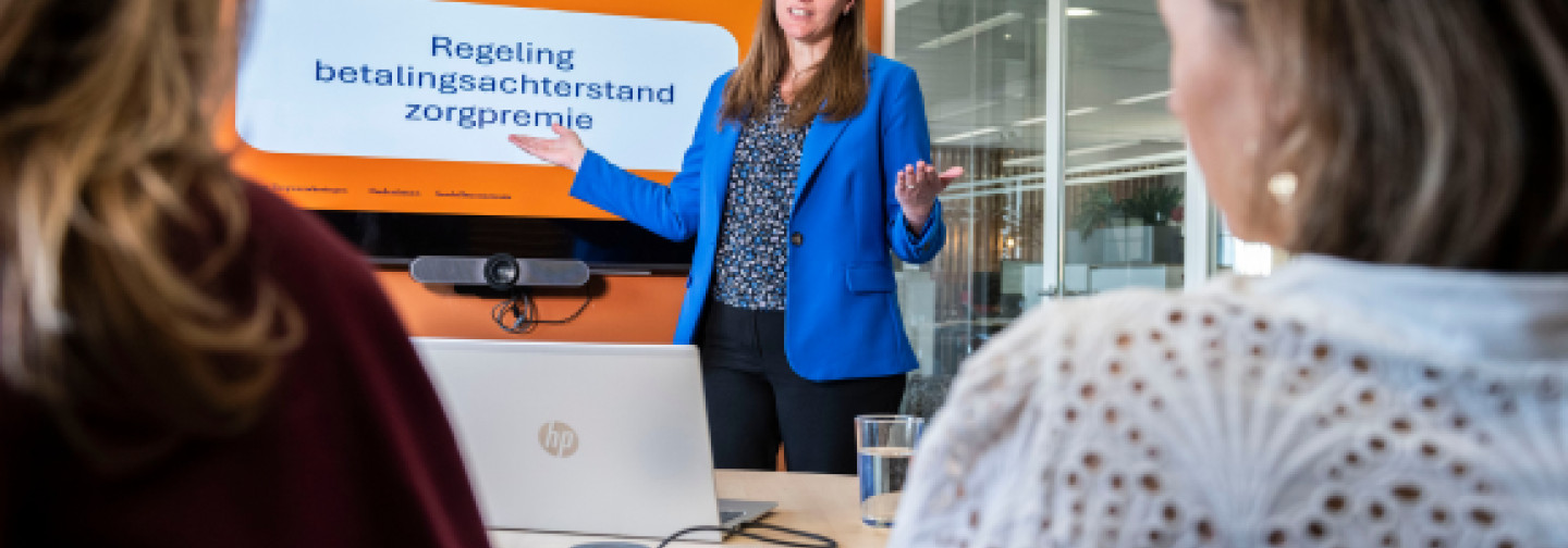 Trainer geeft uitleg aan deelnemers over betalingsproblemen 