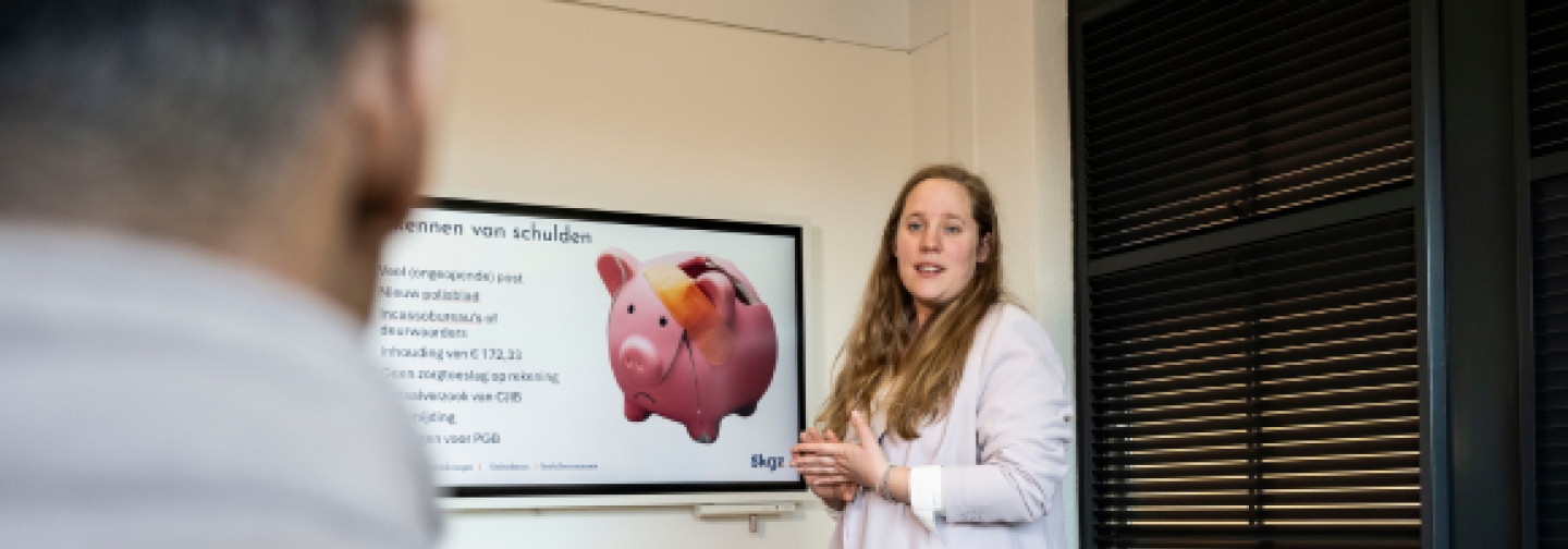 Trainer met deelnemers in gesprek over het aanpakken van beginnende zorgverzekeringsschulden