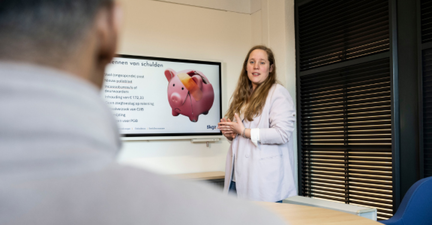 Trainer met deelnemers in gesprek over het aanpakken van beginnende zorgverzekeringsschulden