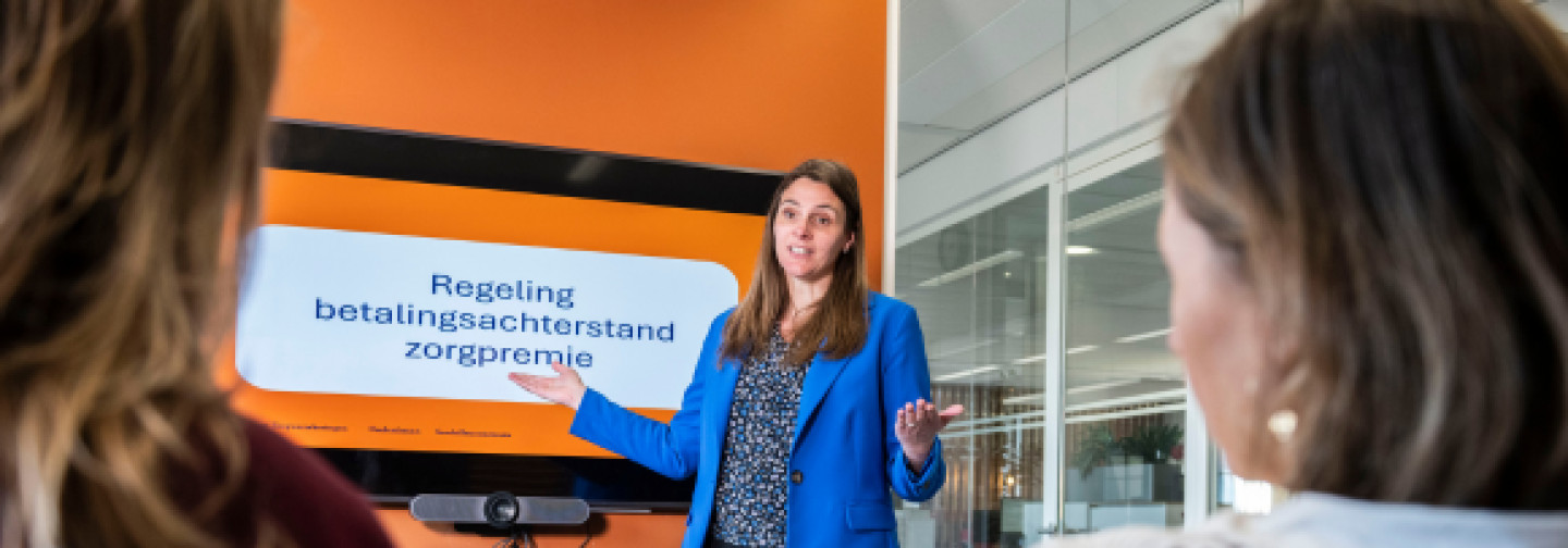 Trainer geeft uitleg aan deelnemers over betalingsproblemen 