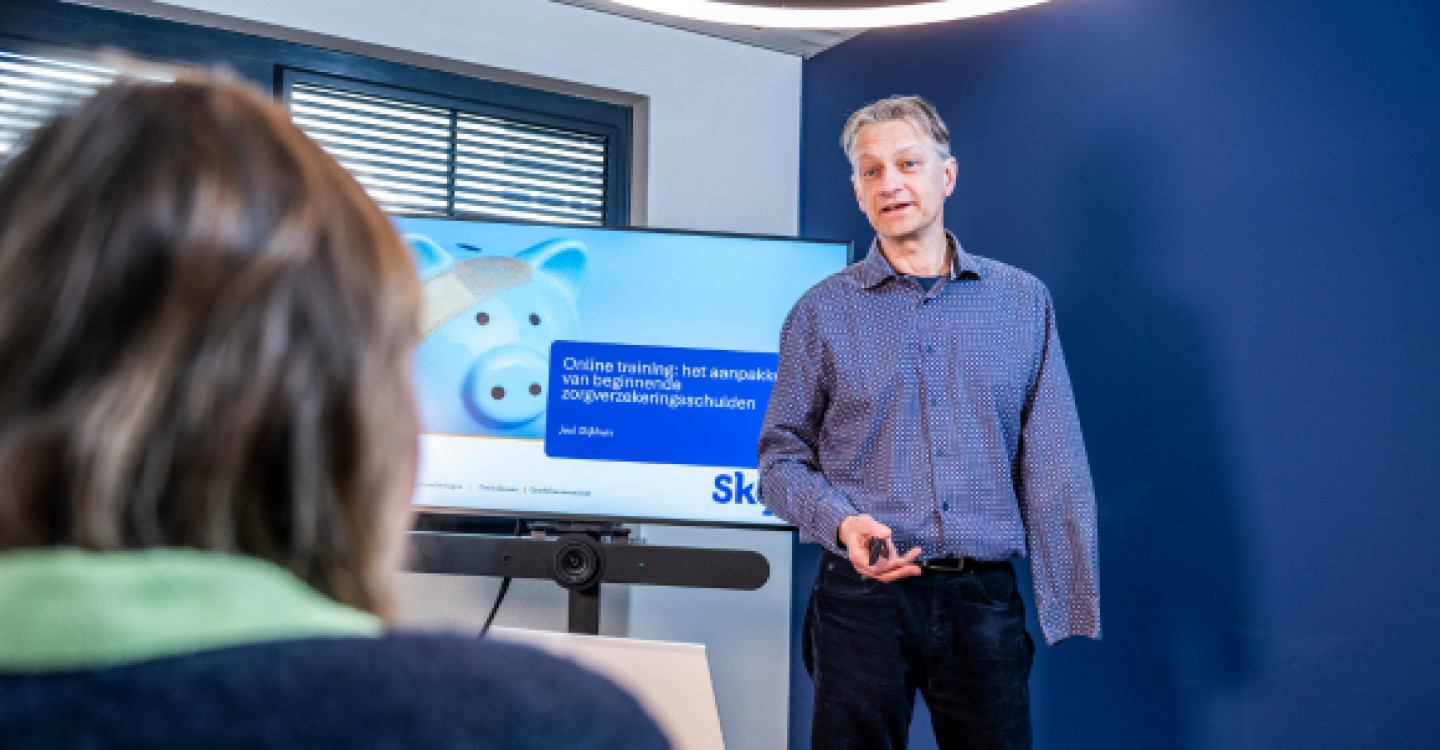 Training geeft uitleg tijdens de online training over de werking van de Nederlandse zorgverzekering